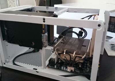 Installing the motherboard into the casing and replace the default rear casing fan with the extra fan from the Noctua CPU cooler.